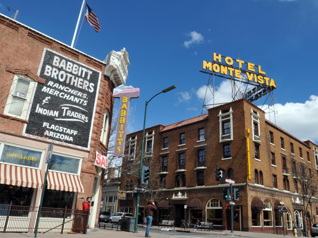 Older style brown brick buildings either side of a road with striped awning