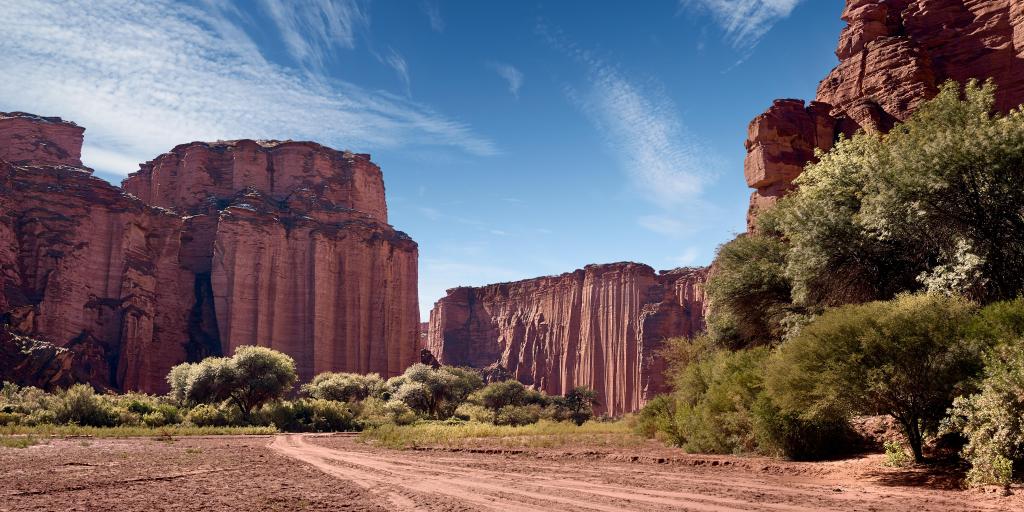 Steep red sandstone cliffs against the red desert in the Talampaya National Park, La Rioja, Argentina.