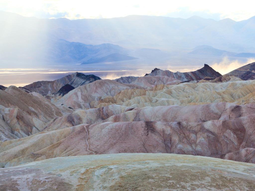 Death Valley National Park, CA, USA with heavy winds kicking up a dust storm in the valley beyond the badlands at Zabriskie Point. 