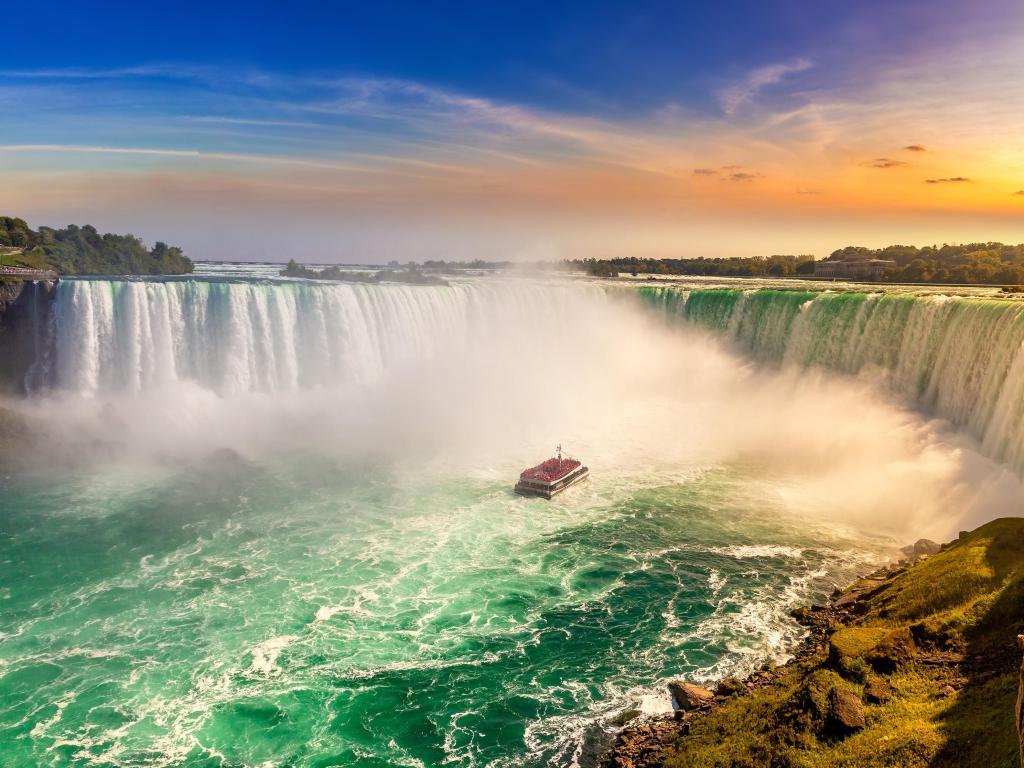 Niagara Falls, Ontario, Canada taken at the Canadian side view of Niagara Falls, with Horseshoe Falls and a boat tour taken at sunset.