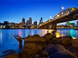 Portland, Oregon, USA with the city skyline in the distance and Willamette River in the foreground taken at night.