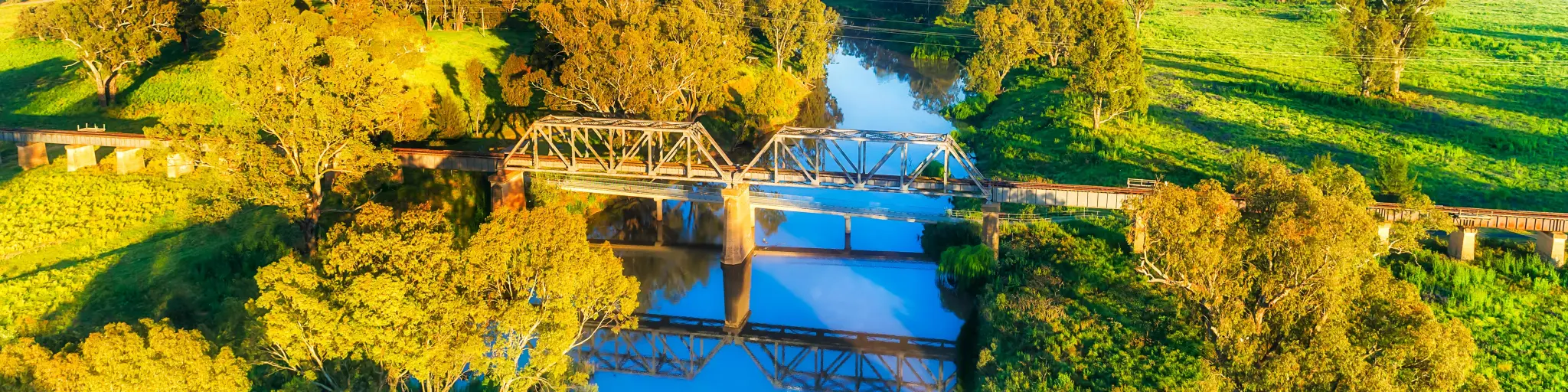 Scenic aerial view of the historic steel railway bridge across Macquarie River in Dubbo, autumn colors