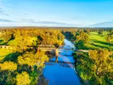 Scenic aerial view of the historic steel railway bridge across Macquarie River in Dubbo, autumn colors