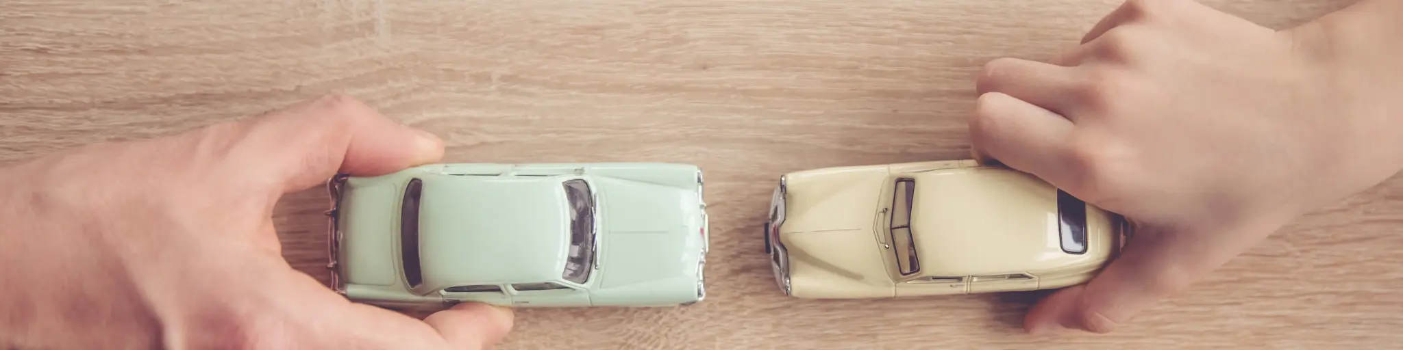 Top down view of a dad and son's hands playing toy cars