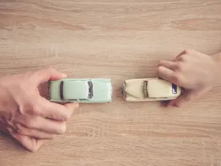 Top down view of a dad and son's hands playing toy cars