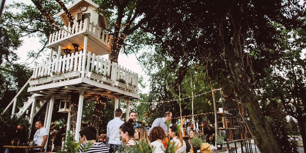 People sitting under a treehouse at Zagreb's A most unusual garden cafe