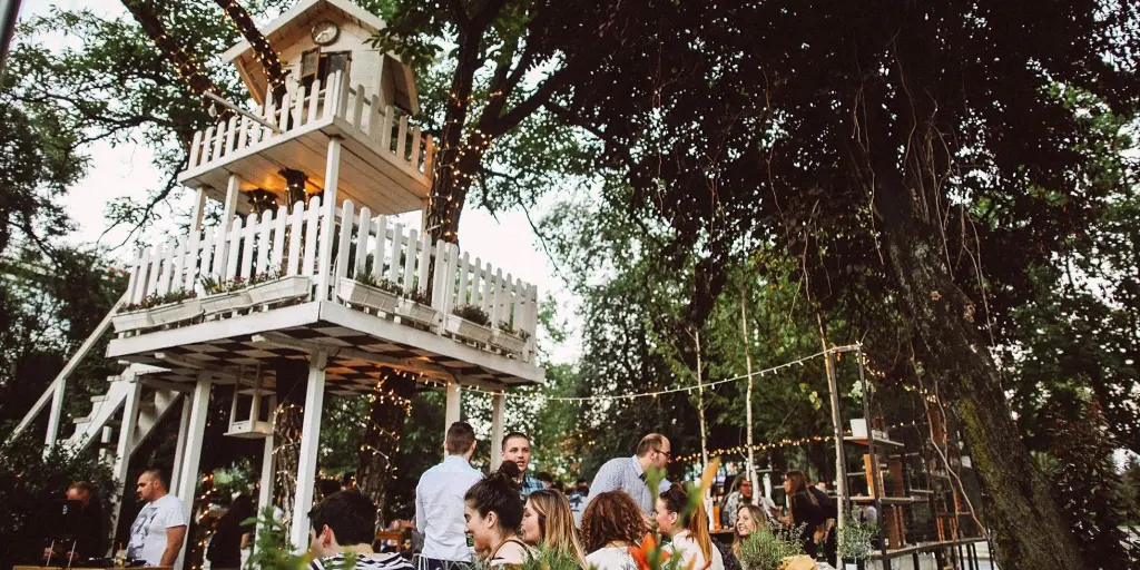 People sitting under a treehouse at Zagreb's A most unusual garden cafe