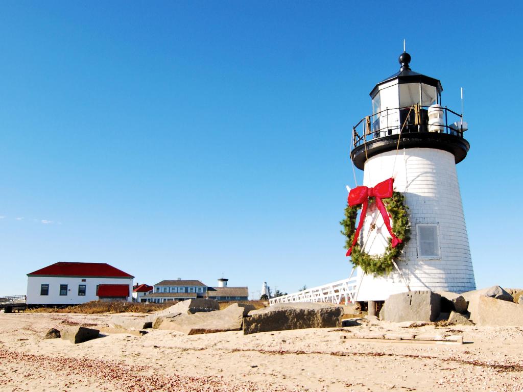 Lighthouse with a big wreath hanging from the front of the facade on a sunny day