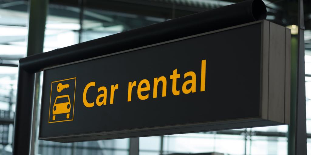 A black and orange sign saying "car rental"