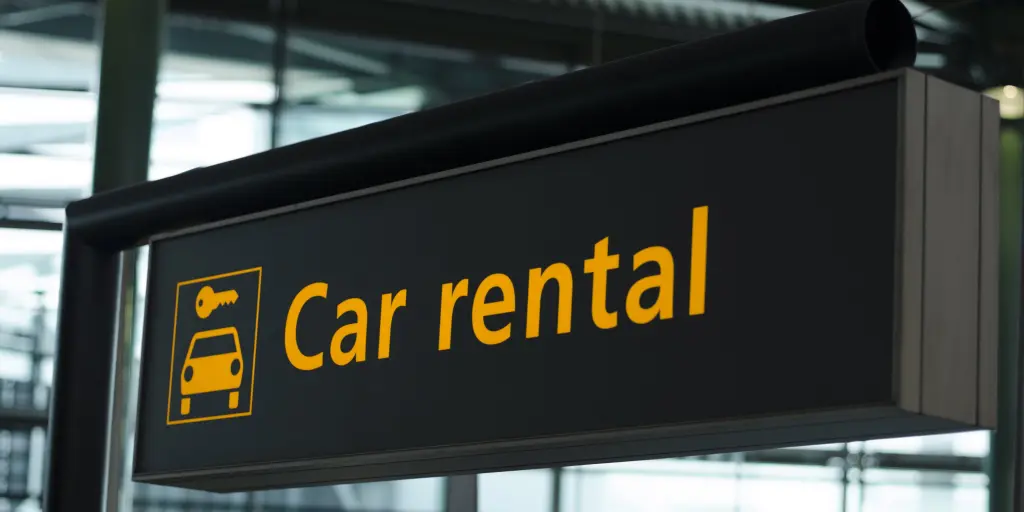 A black and orange sign saying "car rental"