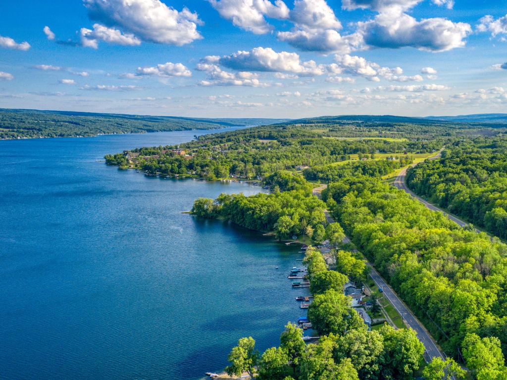 Keuka Lake, The Finger Lakes, New York, USA surrounded by green trees during the summertime.