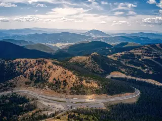 A view of the pass twisting up in the forested mountains on an overcast day