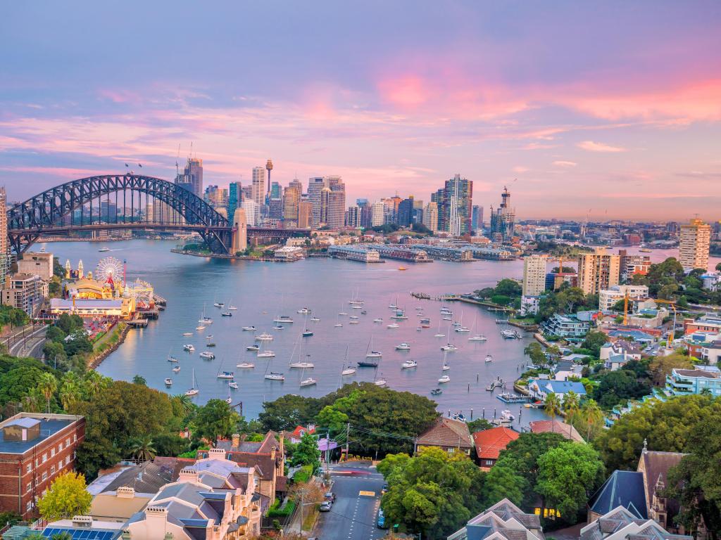 Downtown Sydney skyline at sunset with Harbour Bridge and a purple-hued sky