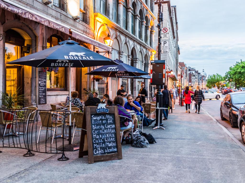 Old town area in Montreal with people sitting by the street at an outside restaurant