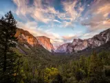 Yosemite National Park, California, USA taken as a view of the valley from Tunnel View just before sunset with pretty clouds in the sky, trees in the foreground.