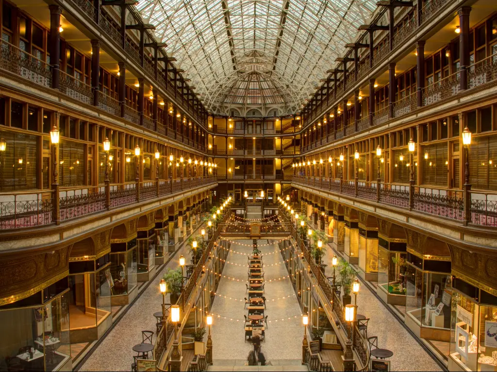 Internal view of The Arcade, a Victorian-era structure of two nine-story buildings, joined by a five-story arcade with an intricate glass roof, long, elegant balconies and chairs set out in a row at ground level
