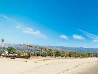 White sand in Santa Barbara shoreline, California with mountains in the background.