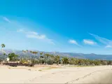 White sand in Santa Barbara shoreline, California with mountains in the background.