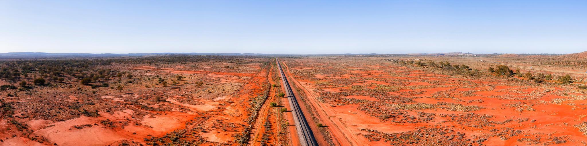 Wide landscape of red soil outback near Broken hill in Australia over railway road track and Barrier highway.