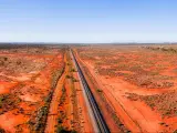 Wide landscape of red soil outback near Broken hill in Australia over railway road track and Barrier highway.
