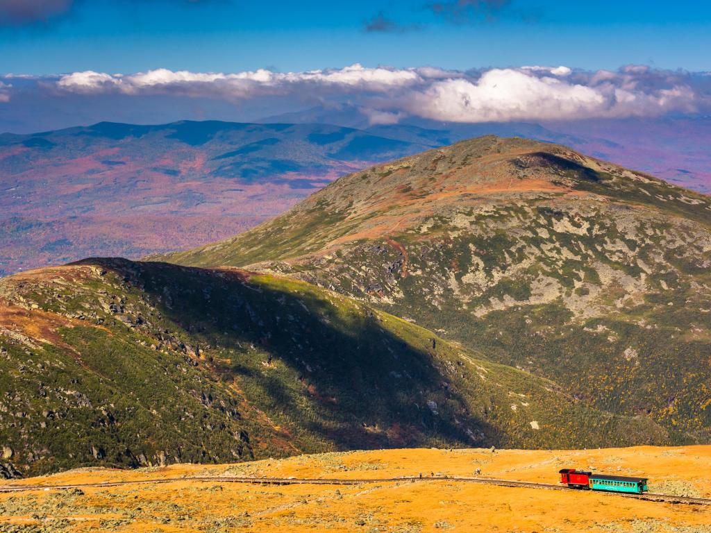 Mount Washington, New Hampshire, USA with a view of The Mount Washington Cog Railway and distant ridges of the White Mountains from the summit of Mount Washington.