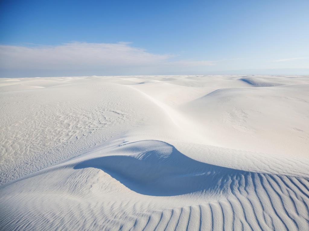 White Sands Dunes in New Mexico, USA with white sands against a blue sky.
