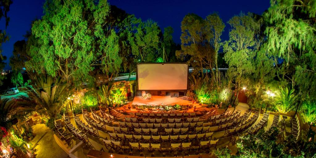 Chairs line up in a U shape in front of a giant screen at Open Air Cinema Kamari