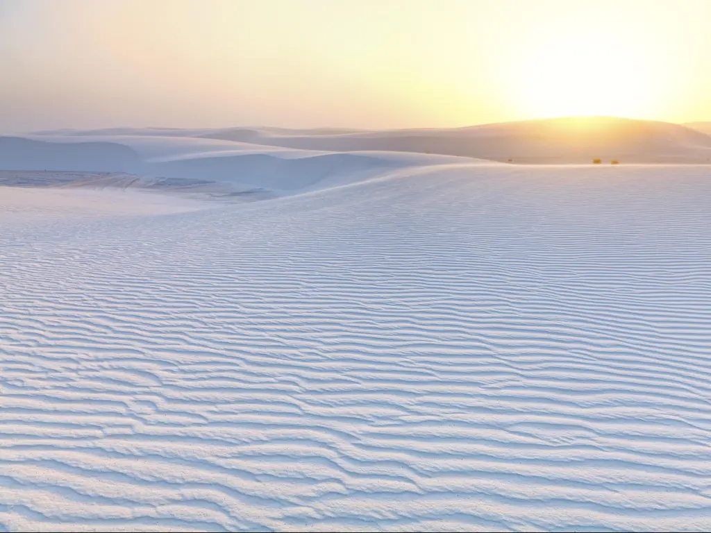 White Sands National Monument, New Mexico, USA with a dramatic sunset and white sand in the foreground.