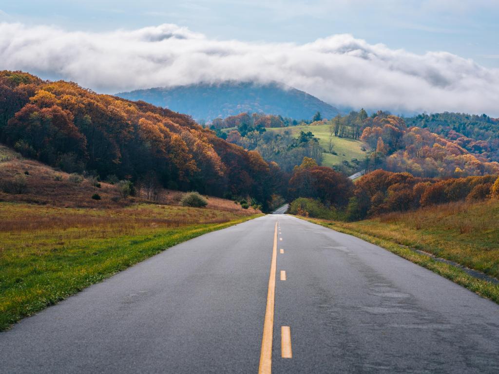 The Blue Ridge Parkway, Virginia, USA with fog over the mountains in Virginia and the road leading into the distance taken during fall.