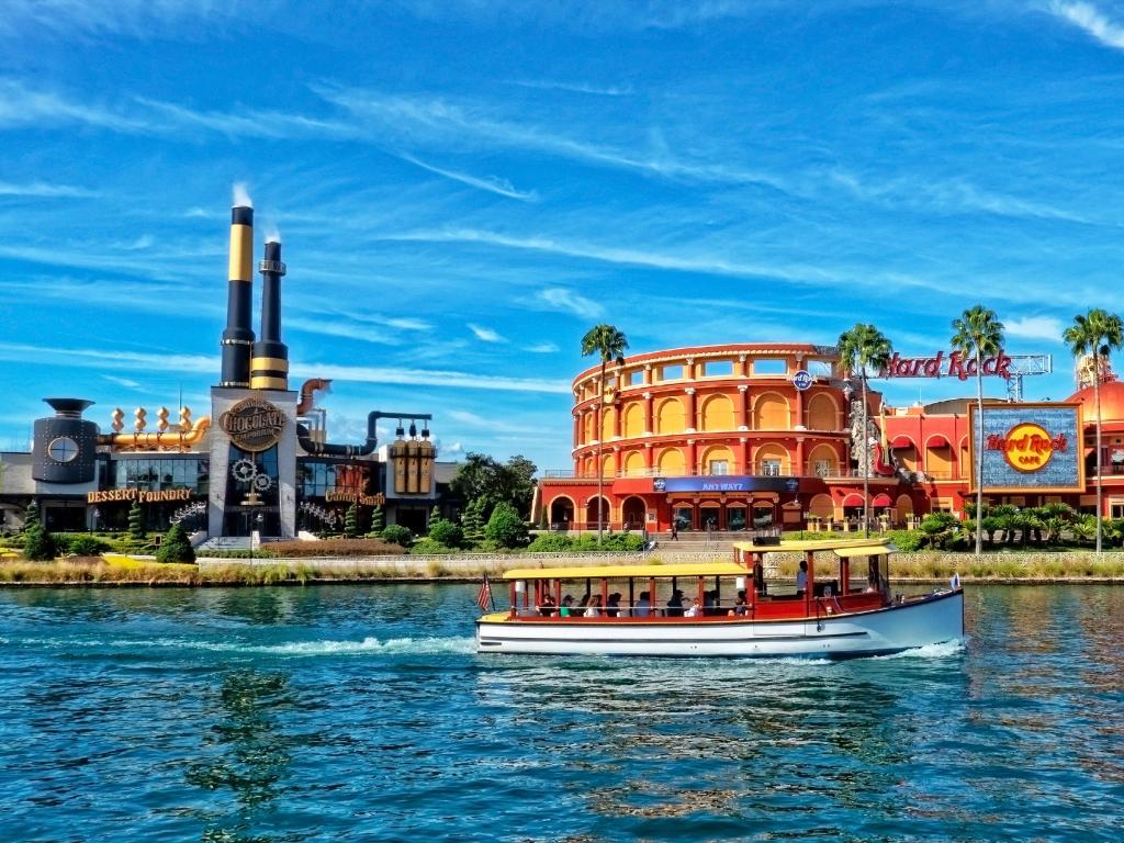 Boats sail past the Hard Rock Cafe and Chocolate Emporium Restaurant at Universal Studio Resort in Orlando, Florida