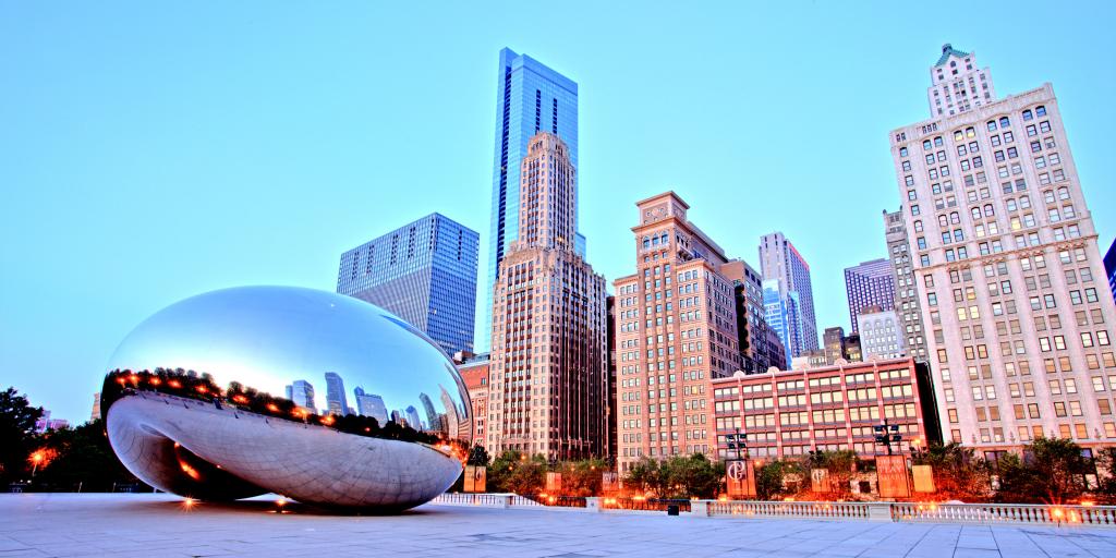 The famous Cloud Gate sculpture sits in front of the Chicago skyline at sunset