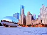 The famous Cloud Gate sculpture sits in front of the Chicago skyline at sunset