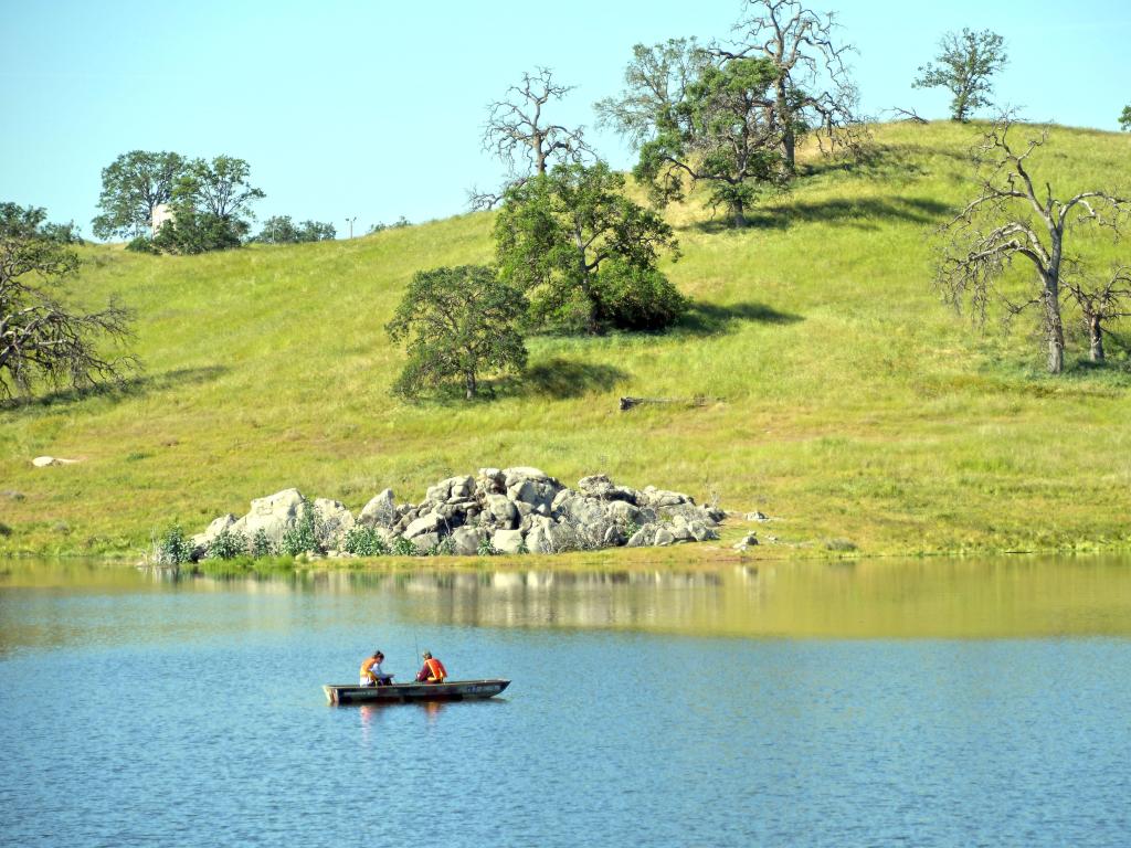 A boat with two people in it on Hensley Lake on a sunny day