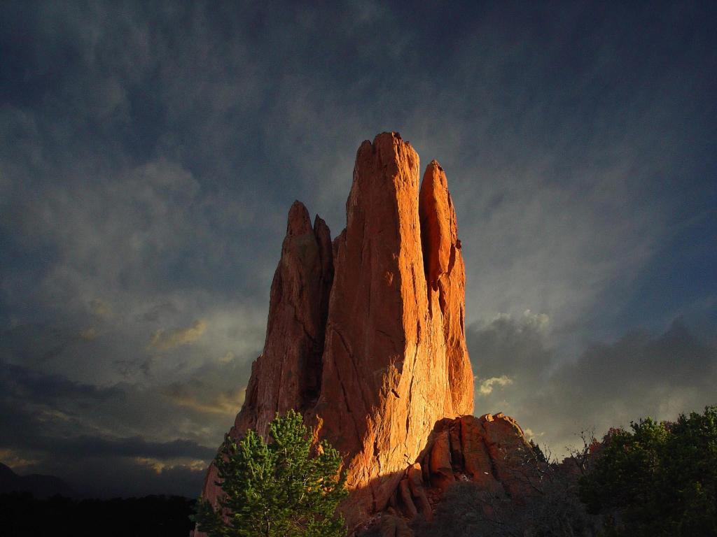 Image of the famous rock formation in the Garden of the Gods during a dark, dramatic sunset