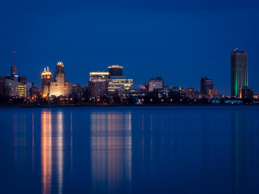 The skyline of Buffalo in New York State taken at night with reflections in the water.