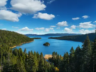 Lake Tahoe on a clear day with mountains in the background and forests in the foreground