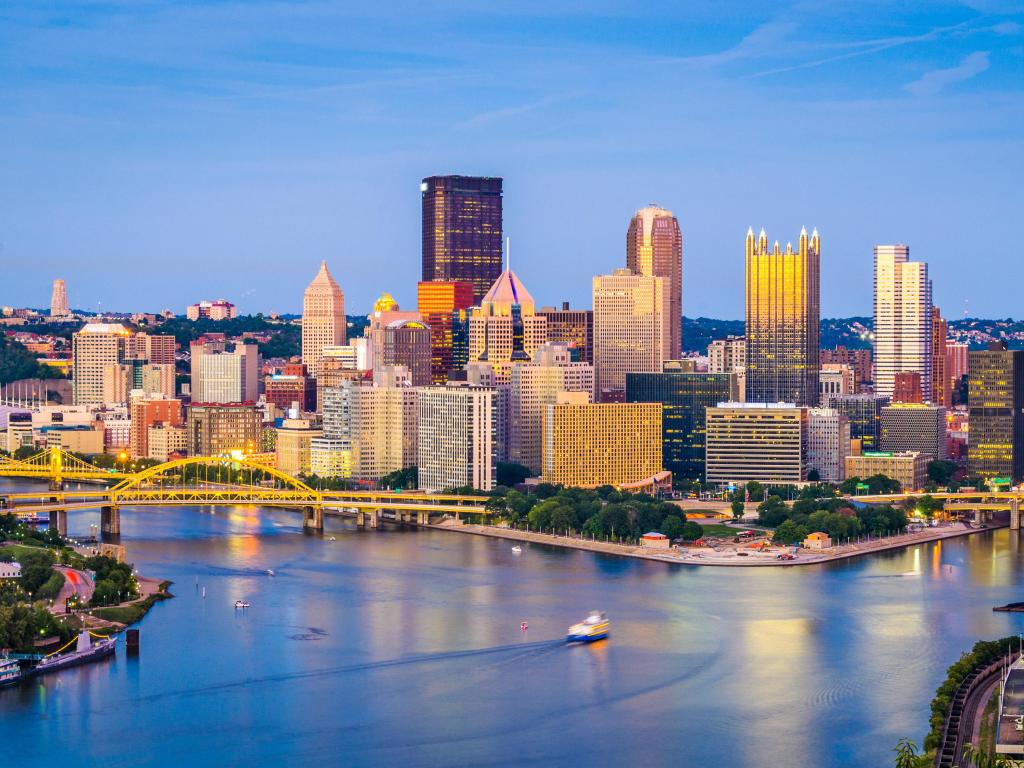 Pittsburgh, Pennsylvania, USA skyline at dusk with the water in the foreground.