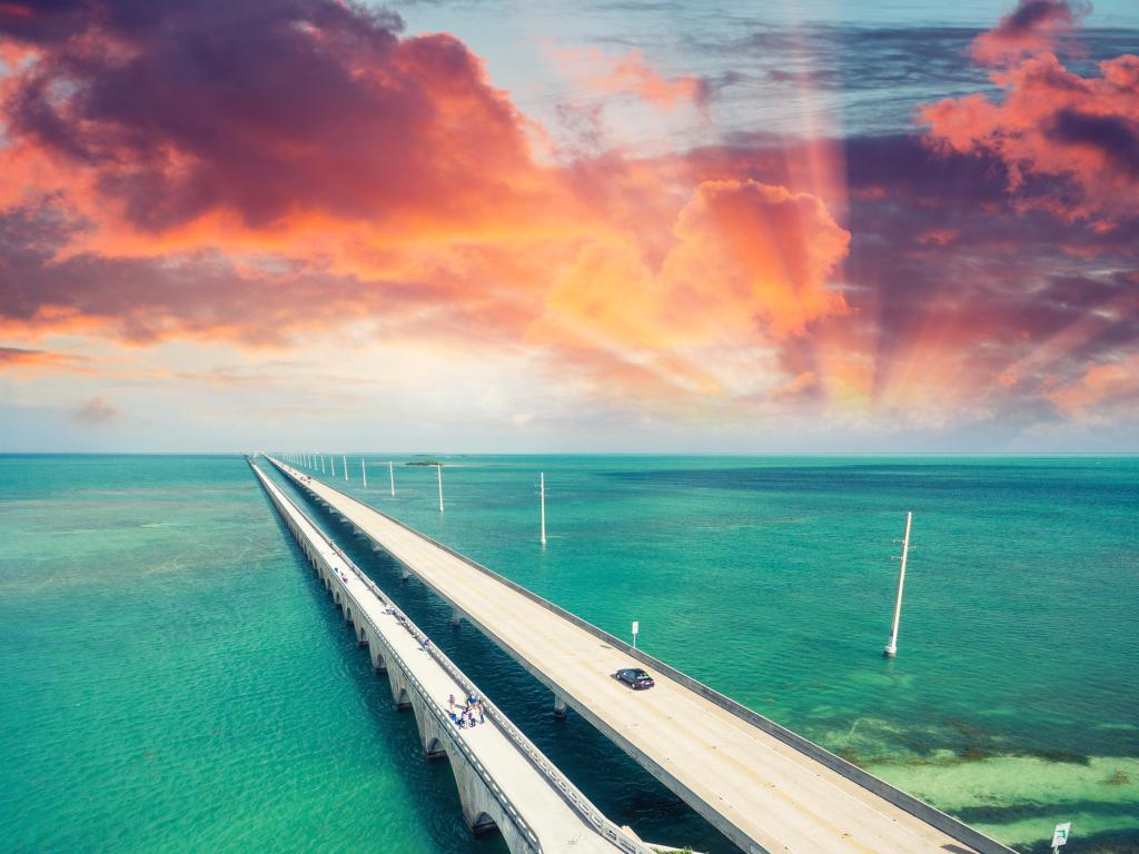 Seven Mile Bridge, Florida with the bridge over the ocean in Keys Islands at sunset with a dramatic sky and above turquoise water. 