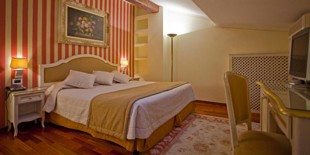 A bedroom with red and yellow striped walls and a skylight at Hotel Porta San Mamolo in Bologna