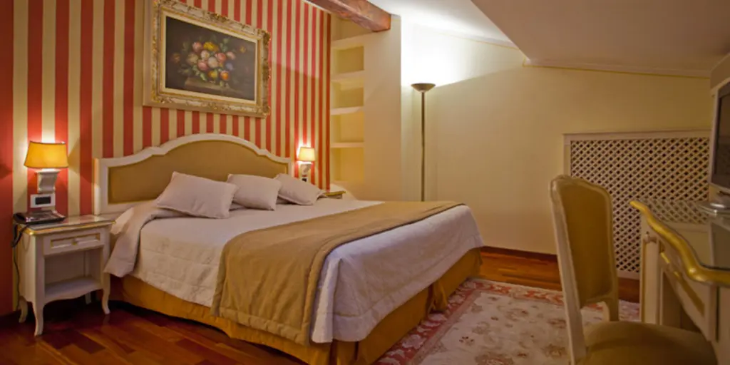A bedroom with red and yellow striped walls and a skylight at Hotel Porta San Mamolo in Bologna