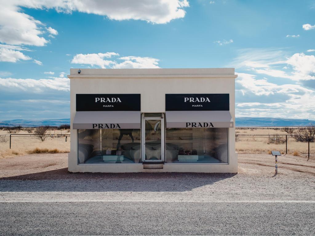 The famous Prada Marfa installation stands at the side of the road at Valentine, near Marfa Texas, on a sunny day