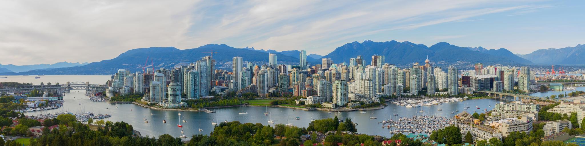 Vancouver, Canada with a panorama view taken from False Creek and the stunning mountains in the distance.