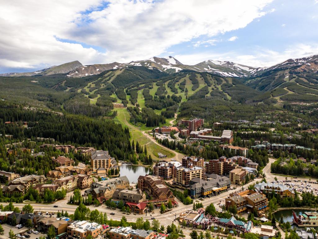 Breckenridge, Colorado, USA taken as an aerial drone photo of the town in the foreground and the rugged rocky mountains in the distance.
