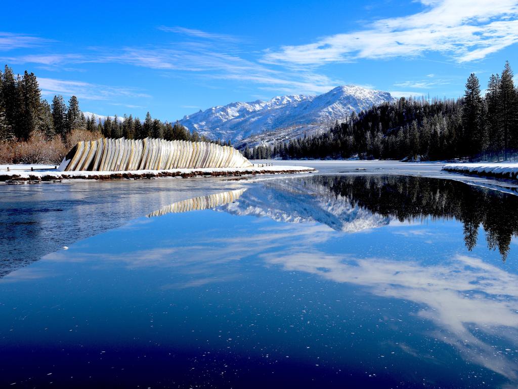 A beautiful winter at Hume Lake, Sequoia National Park, California, USA with snow-capped mountains in the distance.