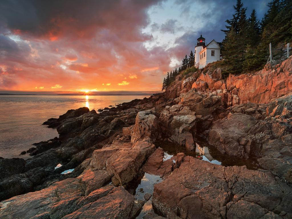 Bass Harbor Lighthouse, Arcadia National Park, Maine, USA taken at sunset with rocks surrounding and the sea. 