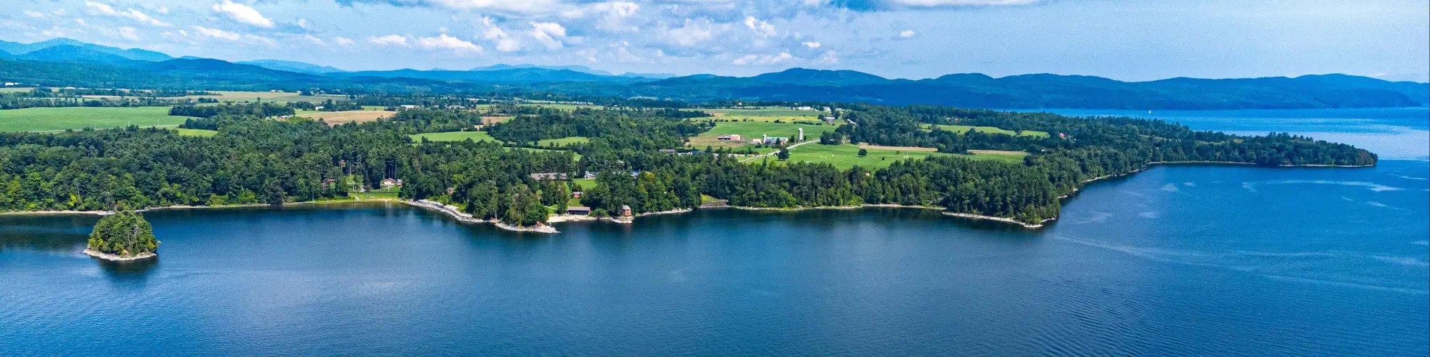 Aerial view of the scenic green landscape and blue lake and skies across Lake Champlain, New York