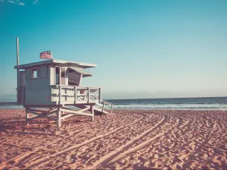 California beach, USA with a view of a lifeguard cabin on Santa Monica beach in California at early sunset, retro toned.