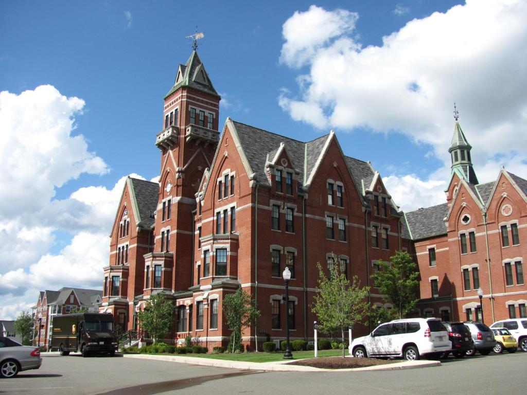 The exterior of the brick-colored hospital on a partially cloudy day