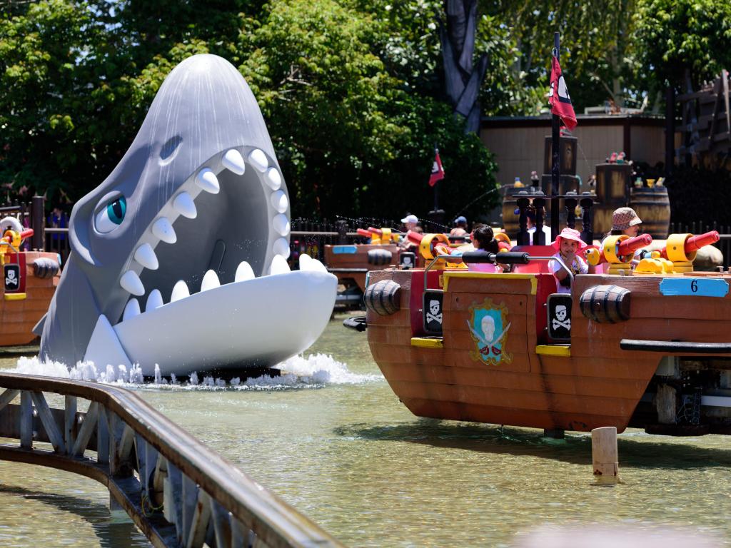 Pirate-themed ride at the amusement park with an animated shark jumping out of the water