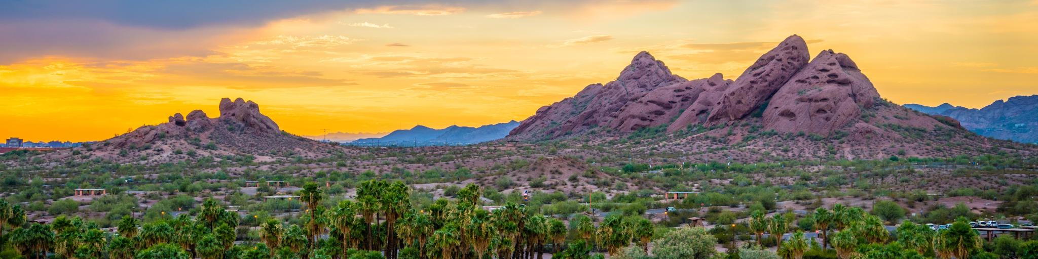 Papago Park, Phoenix, Arizona, USA after sunset with hills in the distance and desert landscape in the foreground.